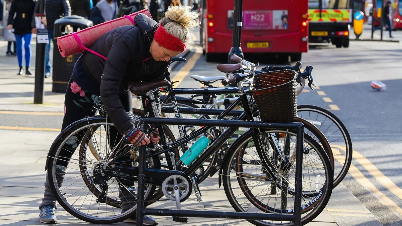 Woman locking up a bike in a busy area