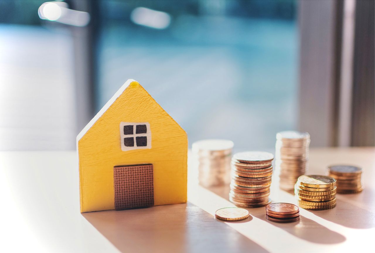 model of house next to coins