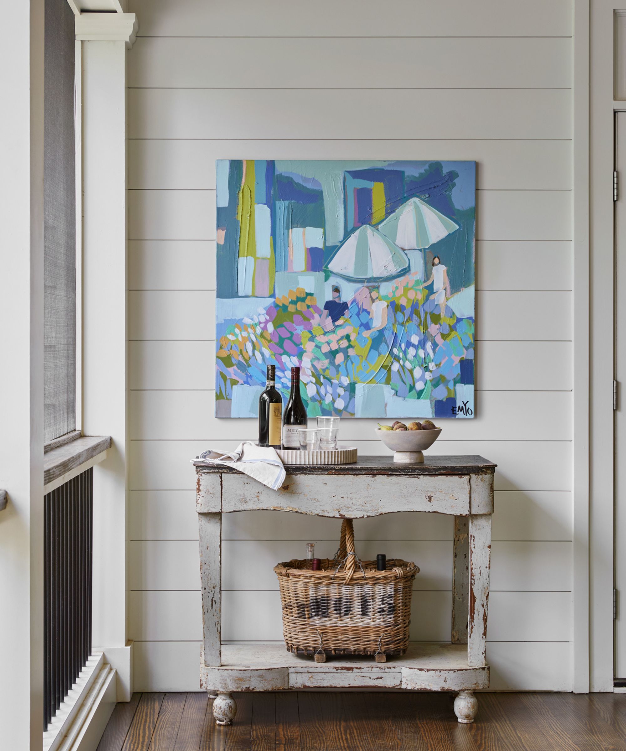 Hallway with shiplap walls, vintage console table, basket and modern art