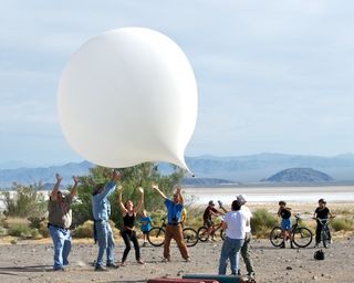 The first attempt to launch the DREAMS-11student balloon in April 2011 fell victim to gusty winds. Here, several scientists try to prevent the balloon from hitting the ground and bursting. 