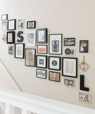 White stairway with different size photo frames on the wall