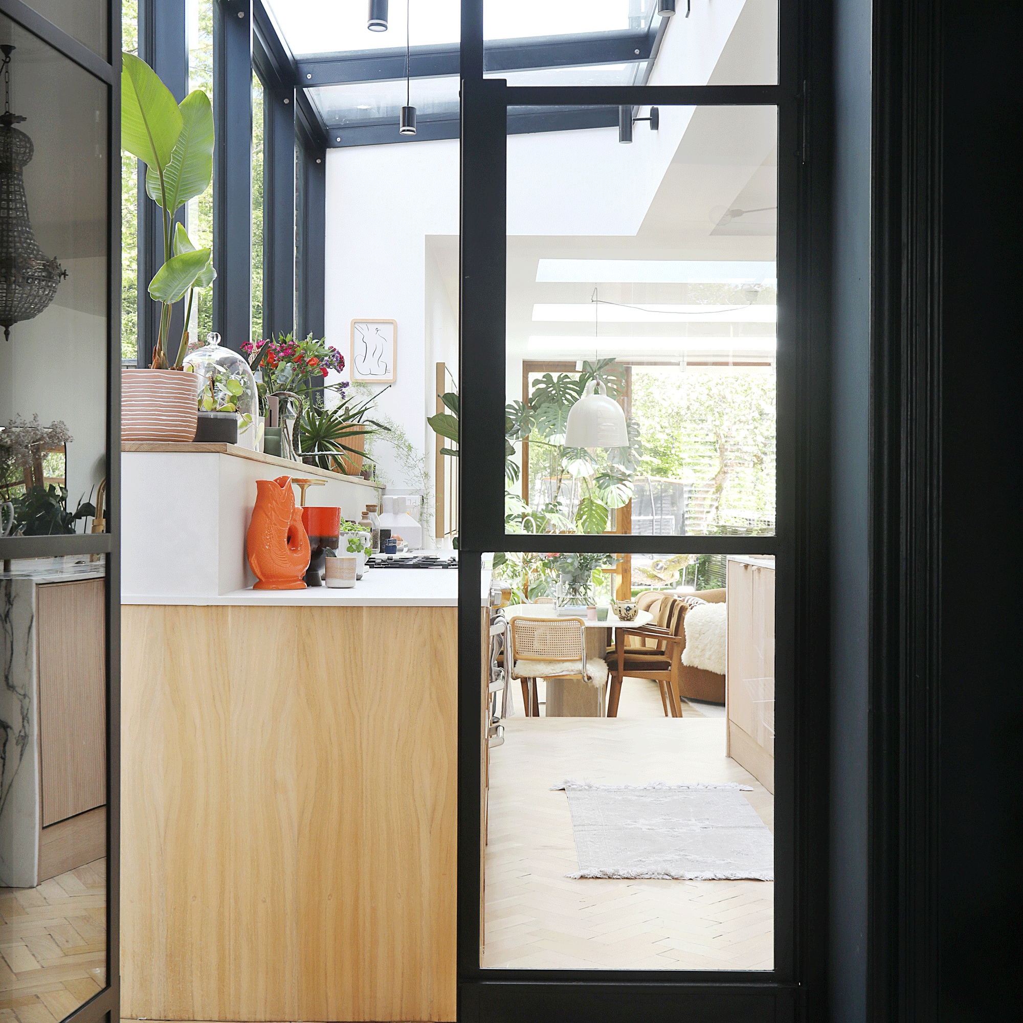 the view through from a hallway into a large open plan space featuring a kitchen dining area and living area