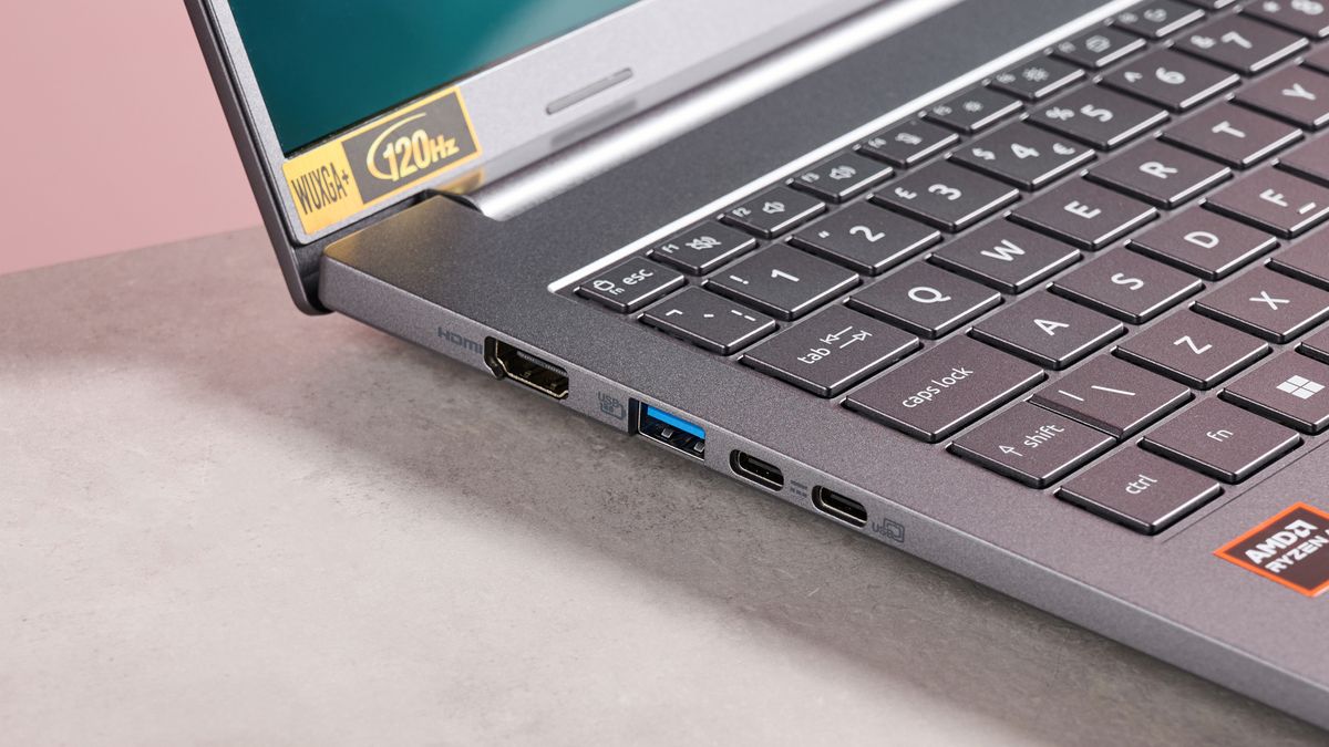 Close-up of left-side ports on Acer Aspire 16 AI, on desk with pink background