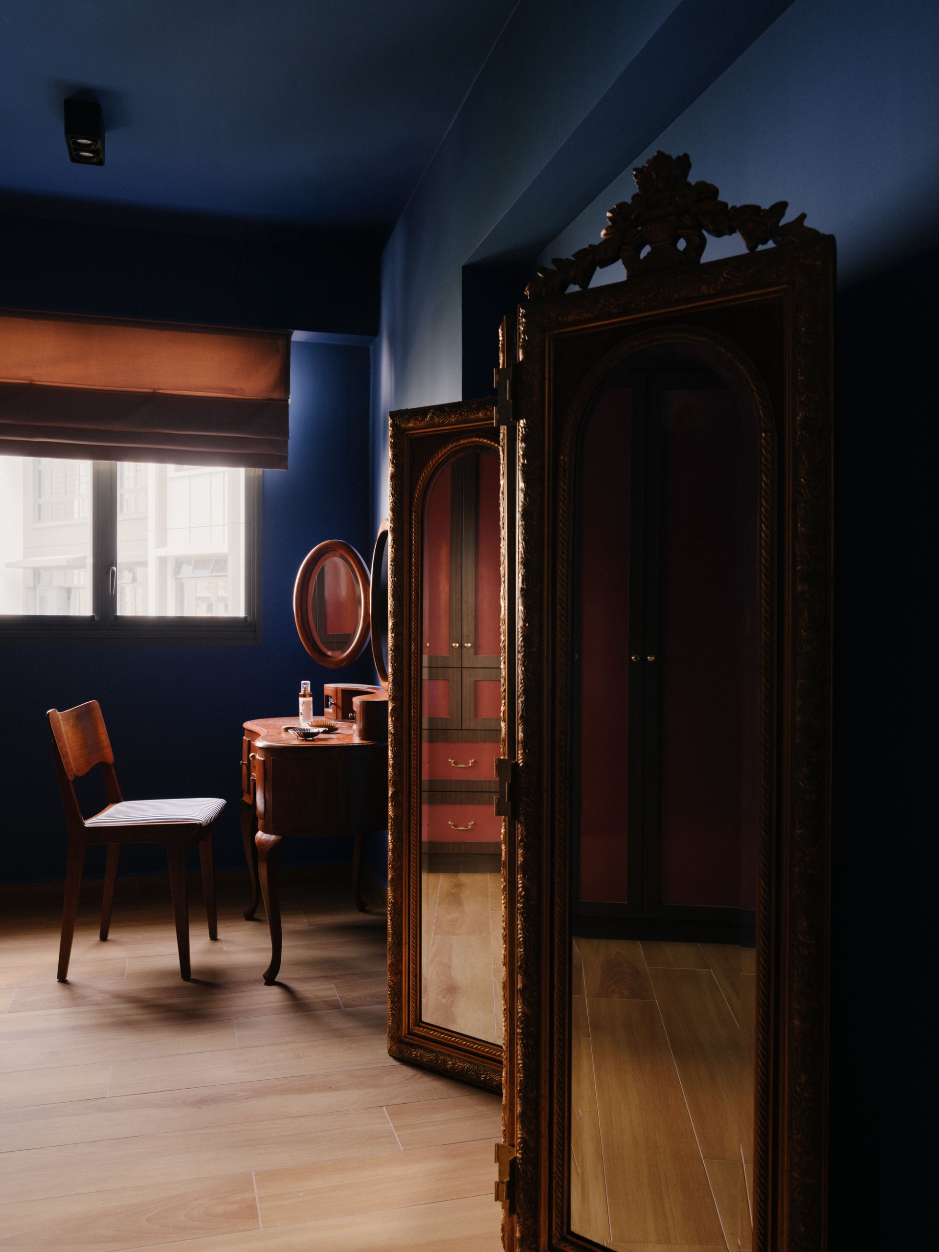 a blue seating nook with vintage vanity and mirrored cabinet