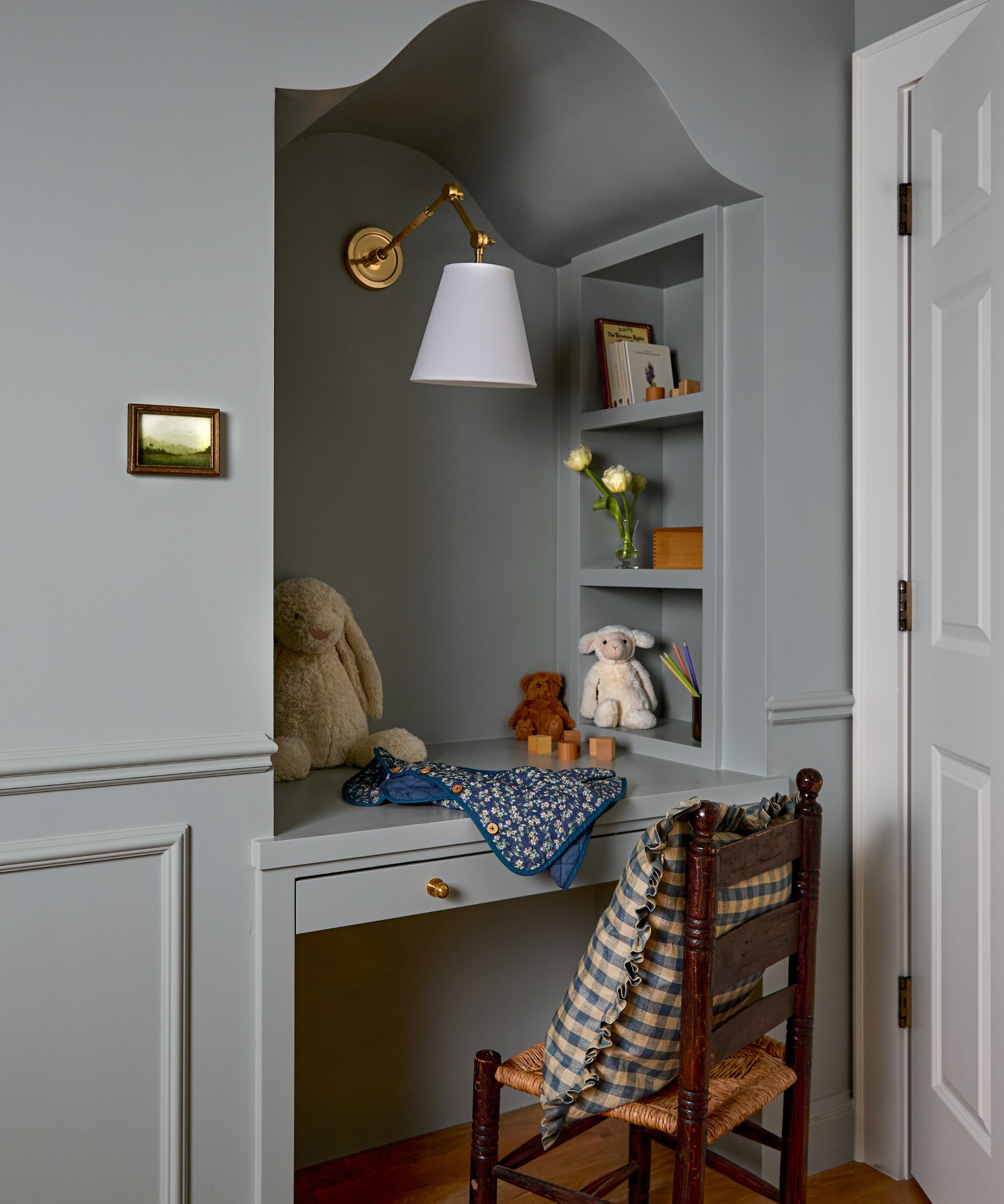 niche alcove in a childrens bedroom painted light blue with a custom desk nook creating for coloring and homework with a vintage wooden chair