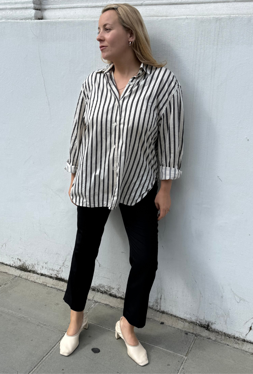 An image of Who What Wear UK acting deputy editor Rebecca Rhys-Evans wearing a striped shirt with With Nothing Underneath's Regent Cigarette Trouser and white ballet pumps.