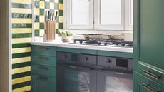 a green kitchen with green and yellow checker board and striped tiles