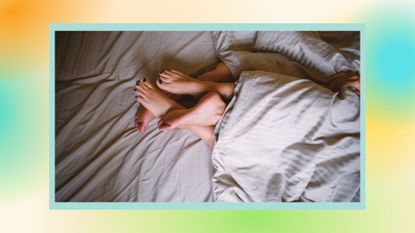 couple's feet intertwined in bed under the cover, with a multi-colored border around the image
