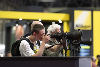 A photograph of a man using a super telephoto lens at TPVS 2023