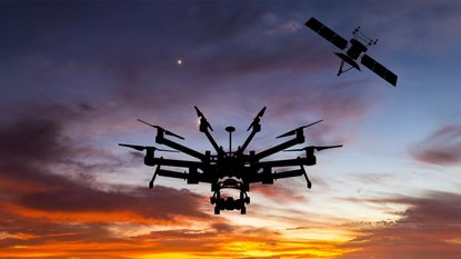 Drone and satellite against the sky at sunset