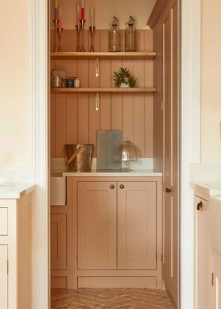 pink utility room with cabinets at the bottom and open shelving above the sink