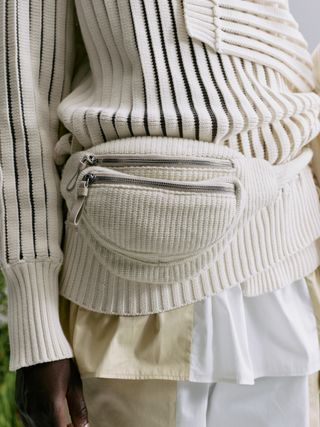 Close up of knitted bumbag on knitted jumper and trousers