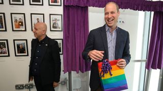 Britain's Prince William, Duke of Cambridge, reacts to receiving a gift bag from trust chief executive officer Tim Sigsworth during a visit to the Albert Kennedy Trust in London to learn about the issue of LGBTQ youth homelessness in London on June 26, 2019. (Photo by Jonathan Brady / POOL / AFP)