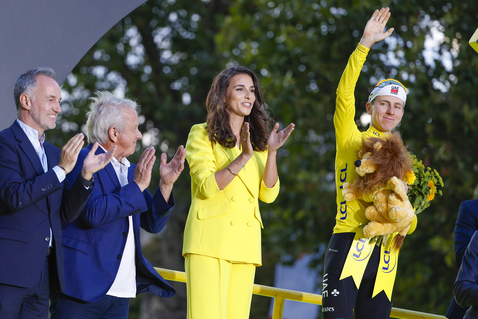PARIS, FRANCE - JULY 26: Winner of the race leader's yellow jersey Tadej Pogacar of Slovenia and UAE Team Emirates - XRG - left Mayor of Paris Emmanuel Gregoire and Greg Lemond - during the podium ceremony following Stage 21 of the 113th Tour de France 2026, final stage of 88,7 km between Paris Champs Elysees and Paris Champs Elysees on July 26, 2026 in Paris, France. (Photo by Jean Catuffe/Getty Images)