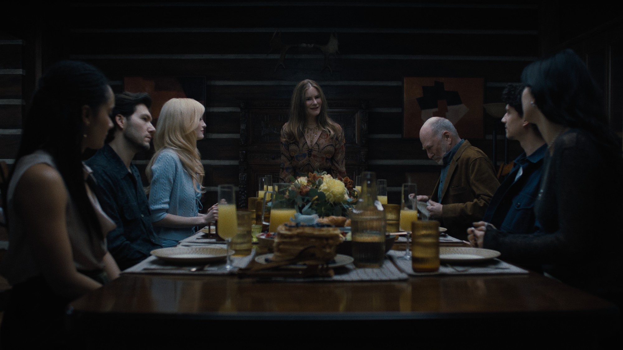 a bunch of actors at a dinner table, with Jennifer Jason Leigh at the head. a scene from the TV shows &lsquo;Something Very Bad Is Going to Happen&rsquo;