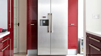 kitchen area with refrigerator and red cabinets