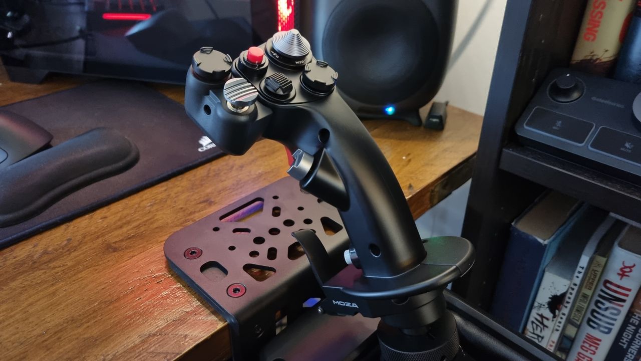 A Moza MH16 Flightstick attached to a Moza AB9 FFB Base unit, clamped to a wooden desk