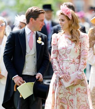 Princess Beatrice wearing a white dress with pink flowers smiling and turning to Edoardo Mapelli Mozzi, wearing a morning suit at Royal Ascot