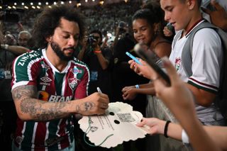 Marcelo signs autographs during his official presentation as a Fluminense player at the Maracana in March 2023.