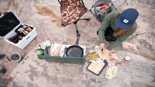 A camper tucking into food in a food container