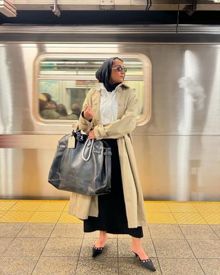 Woman holding the Coach Empire Carryall bag.