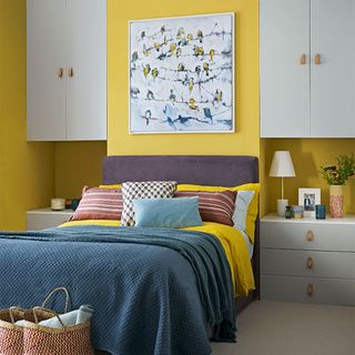 yellow bedroom with cabinets and drawer