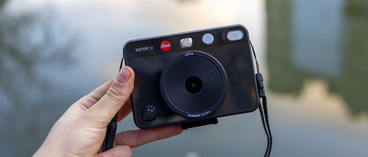 The Leica Sofort 2 being held in front of a cool winter river