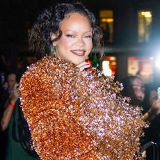 Rihanna attends Mati&egrave;res F&eacute;cales's Spring/Summer 2027 show at Paris Fashion Week, wearing a glittery orange matching set and a peekaboo bra