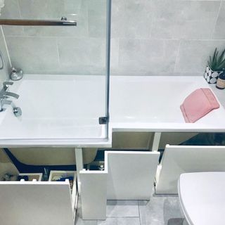 bathroom with under bath storage and bath tub