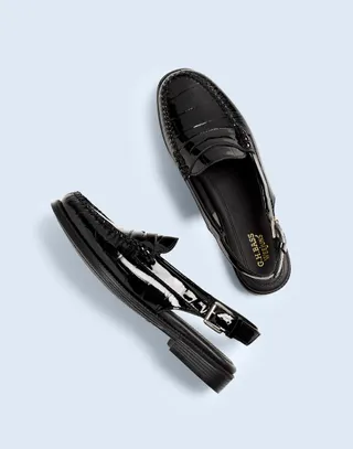 model wears sling back loafer sandals in black patent leather 
