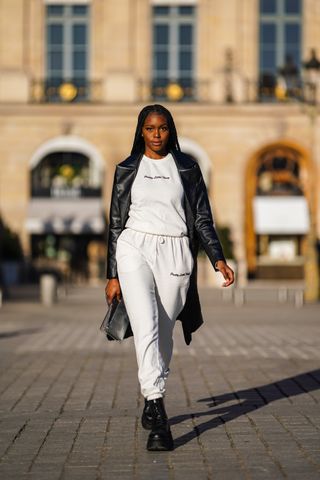 woman wearing sweatpants, a crew neck, a leather jacket, and combat boots