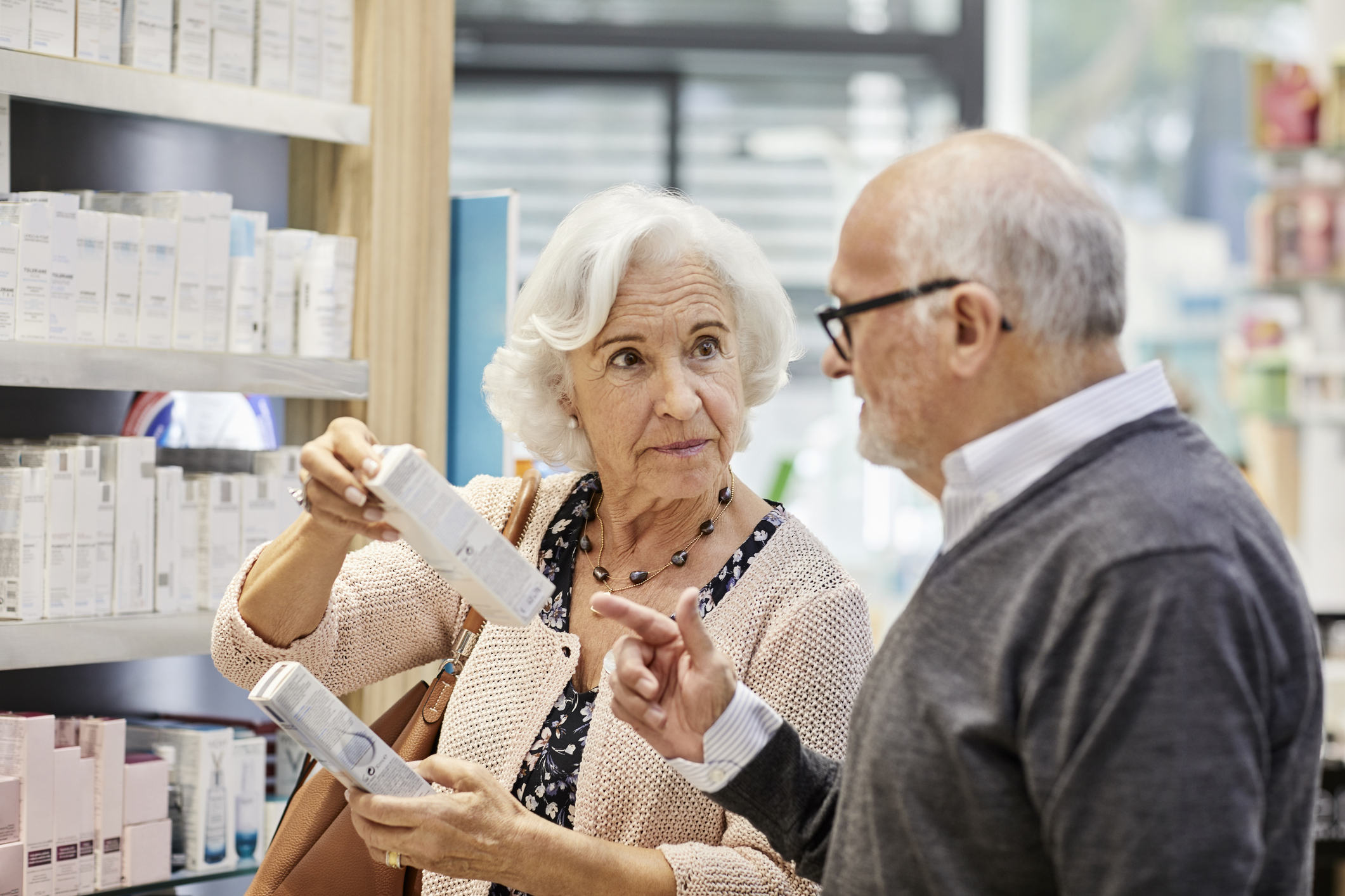 Elderly woman discussing over medicine with man