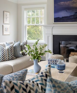 Living room with neutral sofa with coffee table of same height opposite and fireplace