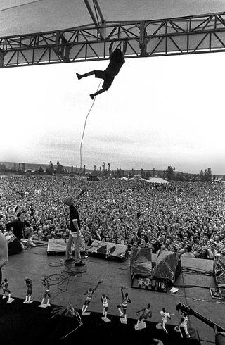 Eddie Vedder dangling from the lighting rig as Pearl Jam headline Drop In The Park in Seattle in ’92