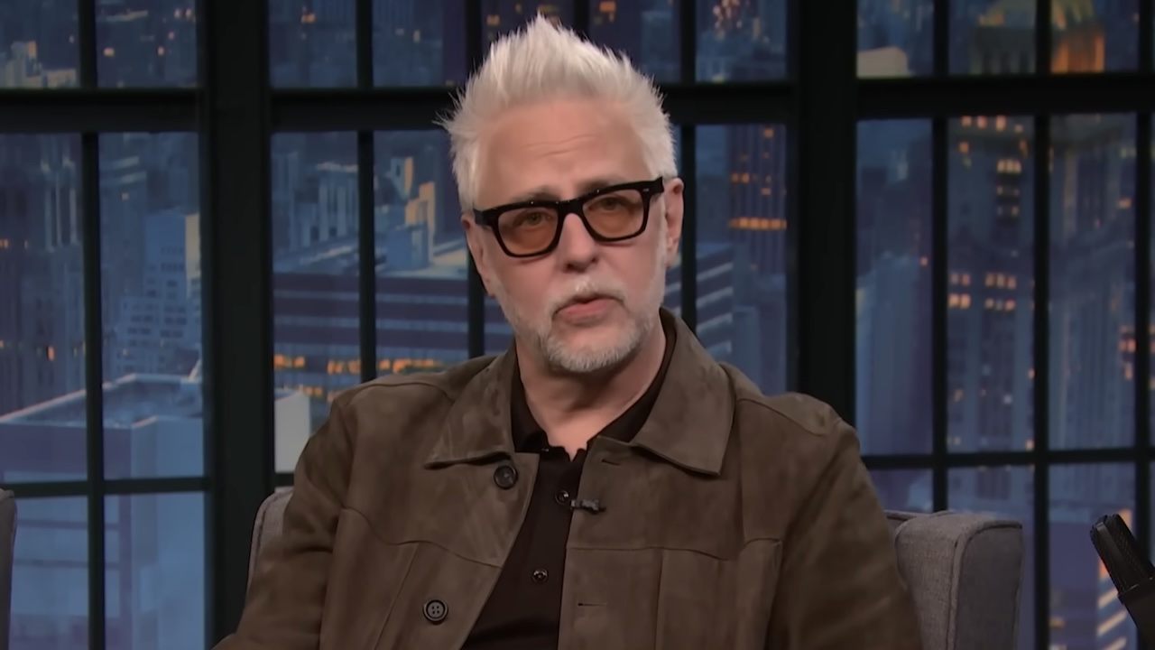 James Gunn in brown jacket talking to Seth Meyers on Late Night