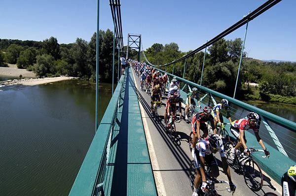The peloton negotiates a narrow river crossing on its way to Nimes.