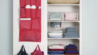 white colour cupboard with cloths and pouch