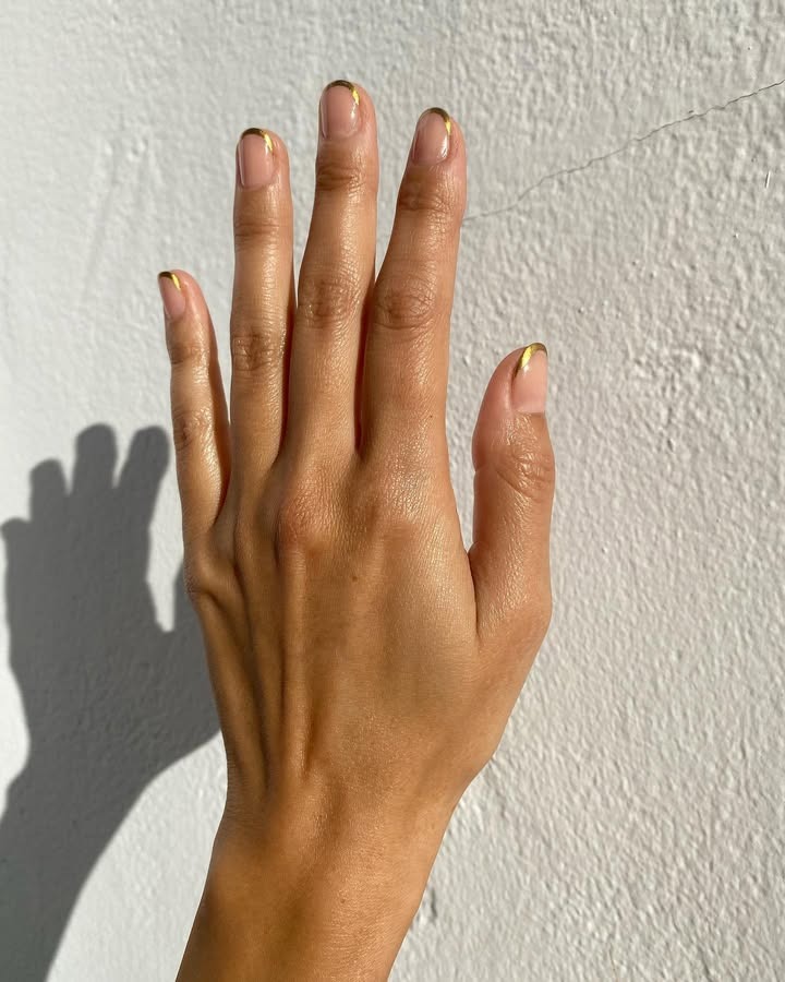 Gold-dipped French tip nails.