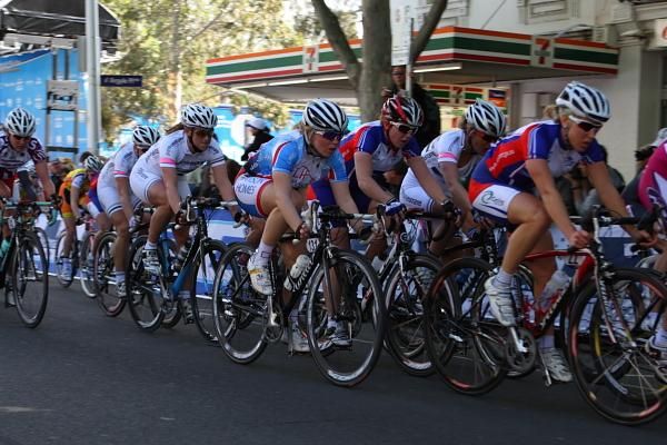 The bunch races along Lygon Street with just a couple of laps to go.