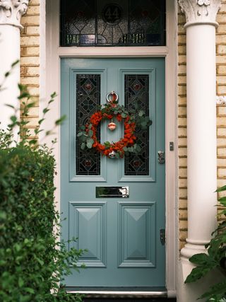 Light blue door with red berry wreath