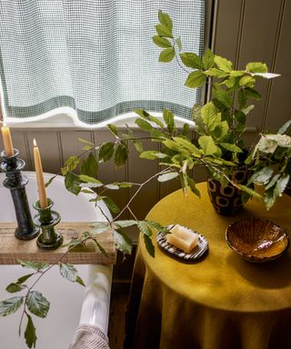 Cozy bathroom with bath, candles and vase of foliage