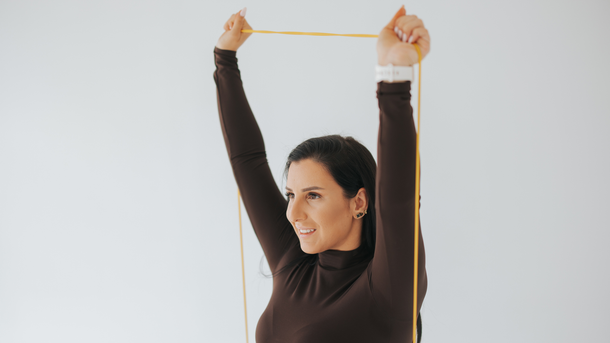 Woman holds resistance band overhead