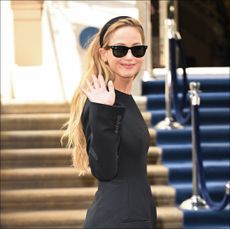 Jennifer Lawrence in a black mini dress, sunglasses, and headband