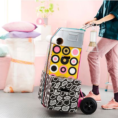 Ikea boxes with trolley and pink wall with cushions