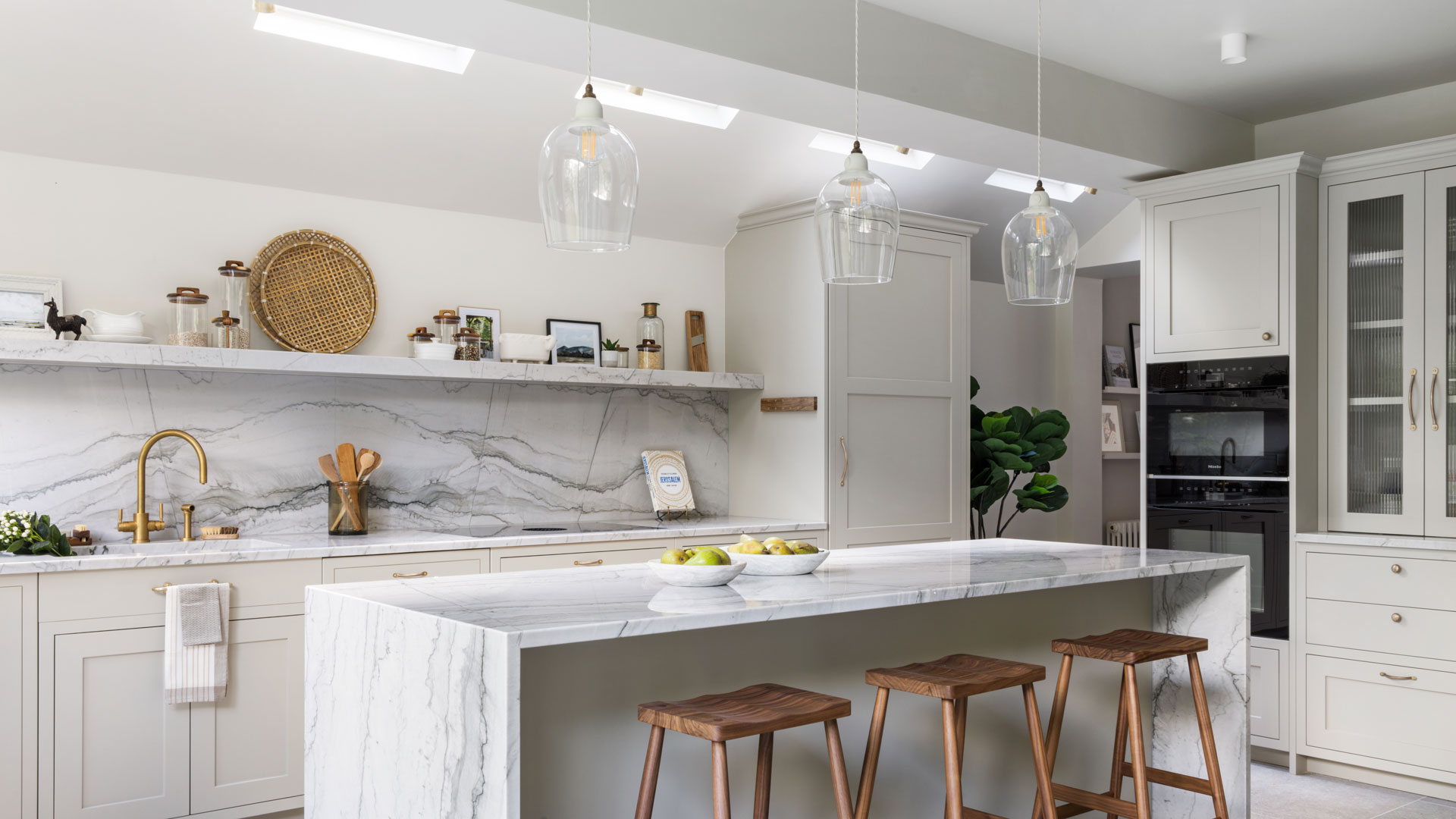 white kitchen with wooden bar stools and marble splashback
