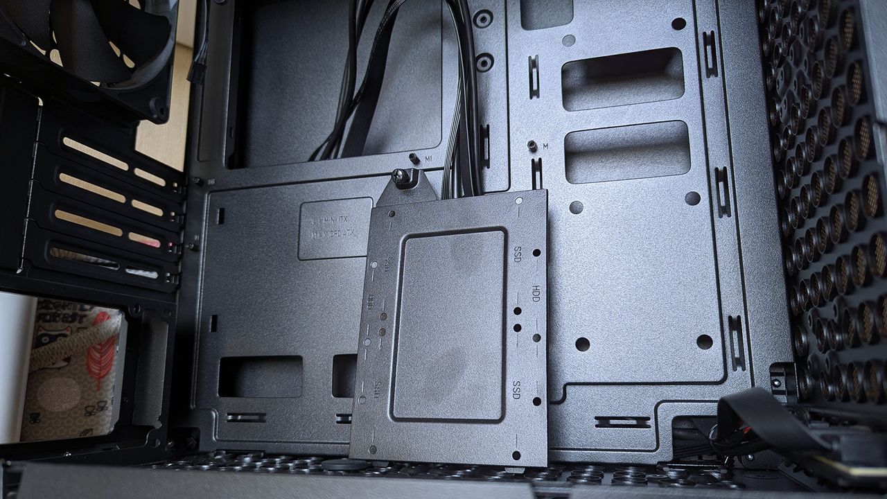 Cooler Master Qube 340 PC case internals showing motherboard tray with standoffs and a detached SSD mounting tray