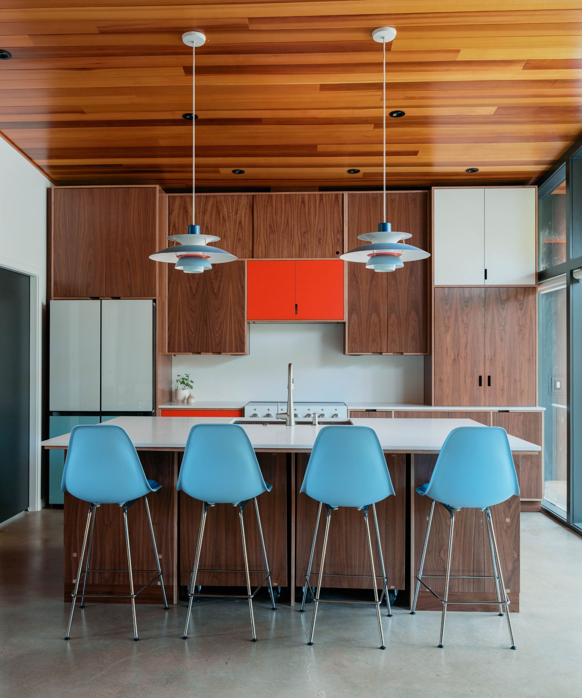 Retro kitchen with wood veneer cabinets and Midcentury pendant lamps over the island