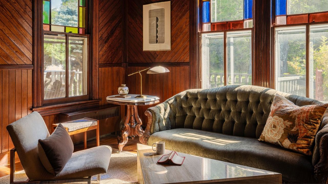 green tufted sofa in wood panelled living room