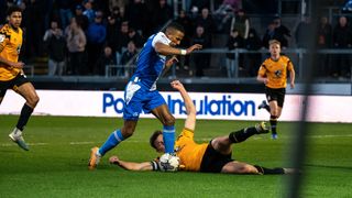 Bristol Rovers soccer player is challenged for the ball which results in a penalty