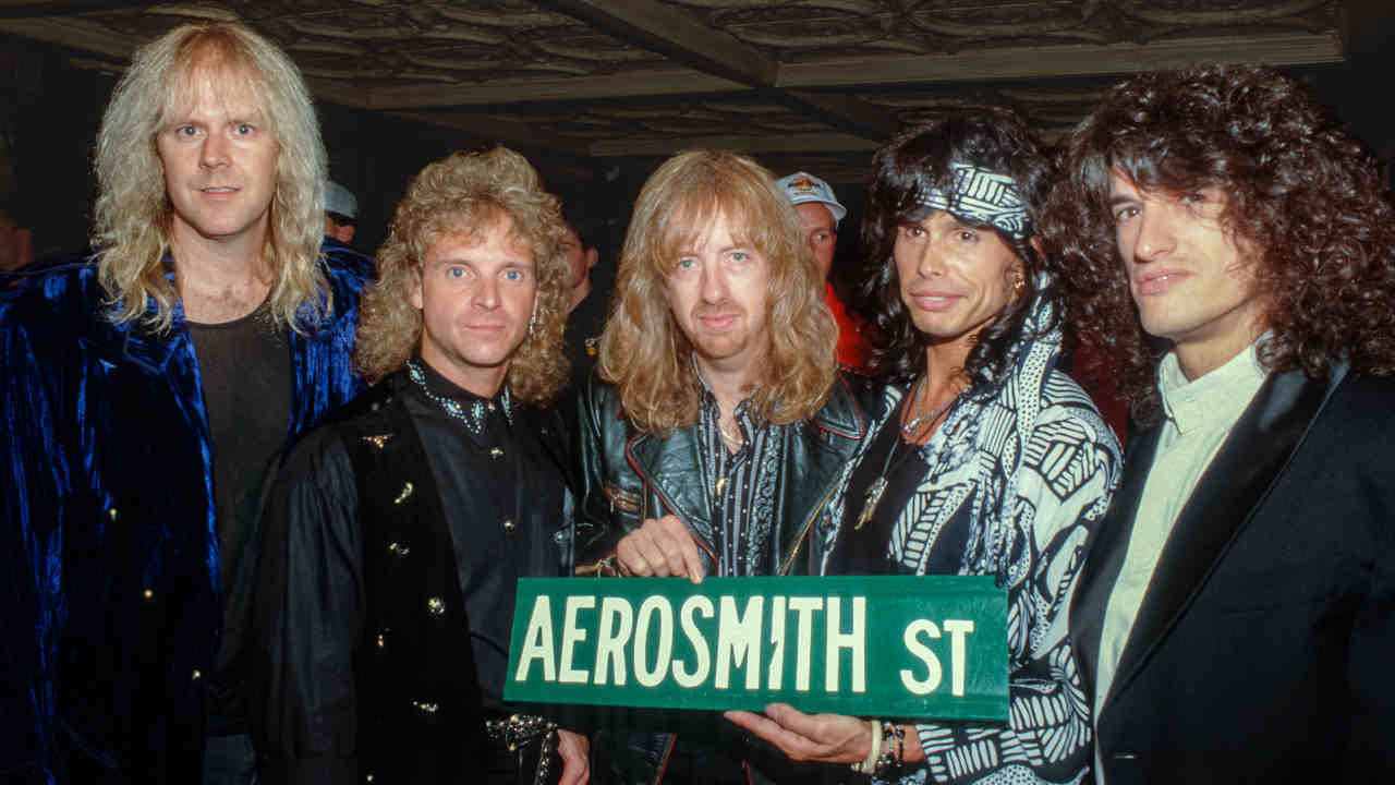 Aerosmith posing for a photograph with an Aerosmith Street sign in 1989